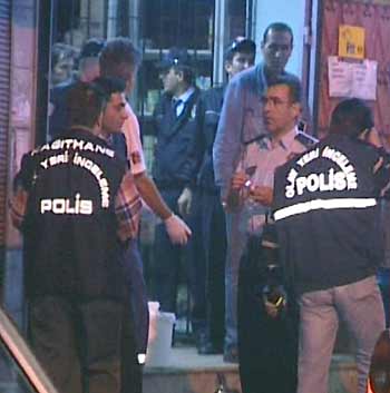 A television grab shows policemen standing outside a shopping arcade after an explosion in the basement of the building in Istanbul October 4, 2005. Police said the blast which killed a person and injured three others, was caused by suspected militant bomb makers.