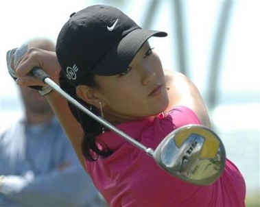 Golfer Michelle Wie hits a shot at Waialae Country Club after giving a news conference announcing that she is turning professional in Honolulu, Wednesday, Oct. 5, 2005. [AP]
