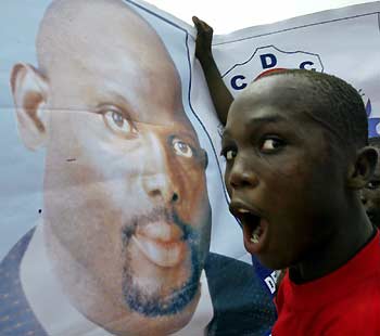 A man shouts while standing in front of a poster of Liberian presidential hopeful George Weah during a rally in Monrovia, Liberia October 8, 2005. Tens of thousands of supporters of Weah brought Monrovia to a standstill on Saturday as the millionaire soccer star held a final campaign rally before Liberia's first post-war elections.