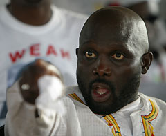 Former international soccer star and presidential hopeful George Weah gestures during a campaign rally for the Congress for Democratic Change at his headquarters in Monrovia October 8, 2005. Tens of thousands of supporters brought Monrovia to a standstill on Saturday as the millionaire soccer star held a final campaign rally before Liberia's first post-war elections.