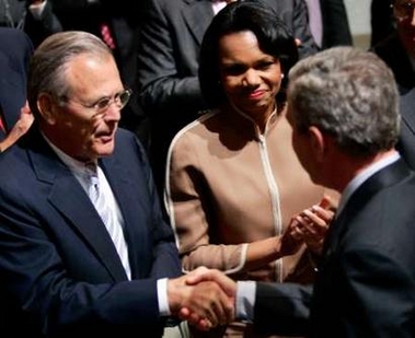 U.S. President George W. Bush (R) greets his Secretary of Defense Donald Rumsfeld (L) and Secretary of State Condoleezza Rice after he delivered a speech on the war in Iraq and the war on terror at the Ronald Reagan Building in Washington October 6, 2005.