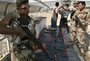 Iraqi National Guard officers keep watch as ballot boxes containing the ballots of the constitutional referendum are loaded into a truck, before being transported to a final vote counting centre, at a polling station in Baghdad October 16, 2005.
