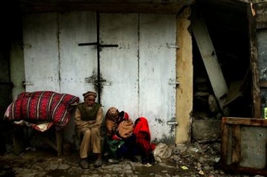 A family group who have lost the mother, takes shelter from the rain in Balakot, Pakistan, Saturday Oct. 15, 2005.