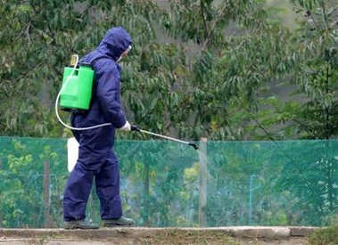 A Romanian health worker sprays dissinfectant in the village of Vulturul, 300km (186 miles) east of Bucharest, Romania Saturday Oct. 15, 2005.
