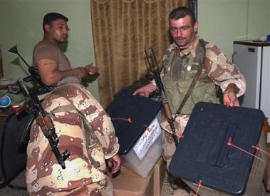 Iraqi soldiers carry ballot boxes at the end of the voting day, in Baqouba, Iraq, Saturday Oct. 15 2005 