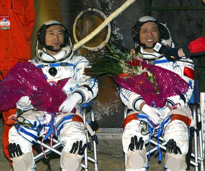 Astronaut Nie Haisheng (R) talks to journalists after he and Fei Junlong got out of the re-entry capsule of the Shenzhou VI spacecaft at the main landing field in Central Inner Mongolia Autonomous Region Monday morning October 17, 2005. The module landed 4:33 A.M. after a five-day flight.