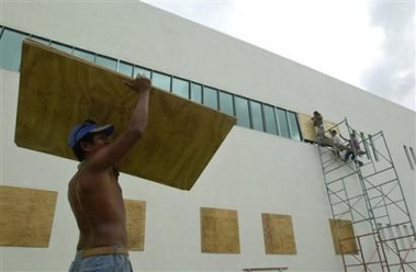 Workers board up the windows of a building in the resort city of Cancun, Mexico, in preparation for the arrival of Hurricane Wilma on Wednesday, Oct. 19, 2005.