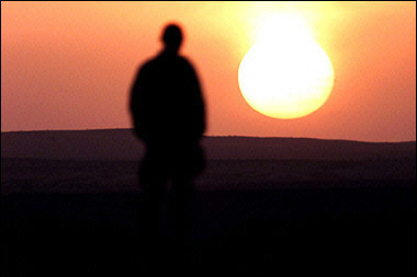A US soldier watches the sunset over the desert in Afghanistan while on patrol. The United States expressed concern about film of US soldiers burning the bodies of two suspected Taliban militants which comes as a new blow to the image of the US military.(AFP