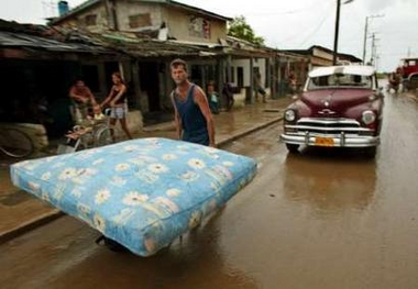 A Cuban man moves a mattress to higher ground as Hurricane Wilma approaches in Batabano, Cuba October 20, 2005.