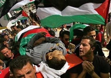 Palestinian mourners carry the body of Abdullah Tamimi, 18, through the streets of the West Bank village of Deir Nizam, near Ramallah, during his funeral procession Sunday, Oct. 23, 2005.
