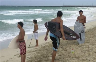 Boys with skimboards watch and wait for waves at the southern tip of Miami Beach, Fla., Sunday, Oct. 23, 2005, as Hurricane Wilma accelerated toward storm-weary Florida, threatening residents with 105-mph winds, tornadoes and a surge of seawater that could flood the Keys and the state's southwest coast. (AP