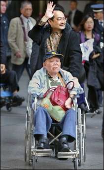 Taiwanese plaintff Wang Jiang-He, 79, (front) and a supporter leave the Tokyo District Court.