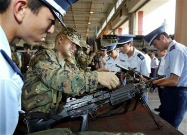 U.S. Marines demonstrate their weapons to visiting Japanese Self-Defense Force cadets at Camp Schwab on Japan's southern island of Okinawa in this June 19, 2003 file photo.