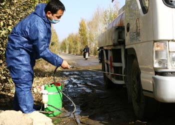 Health workers disinfect vehicles coming out of Bayan township near Hohhot in the Inner Mongolia Autonomous Region October 24, 2005, following the deaths of 2,600 birds from H5N1 bird flu strain in a farm there last week. [China Daily]