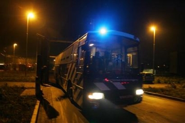 A bus carrying inmates leaves from a prison facility at Schiphol airport, Amsterdam, Netherlands, Thursday Oct. 27, 2005, after a fire broke out which claimed the lives of at least ten people and wounded fifteen. (AP