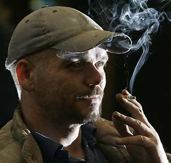 A man smokes a cigarette at a private club in Burnley, northern England, October 26, 2005. The British government will publish its plans on Thursday for a ban on smoking in public places in England, stopping short of a blanket ban after ministerial wrangling. Health Secretary Patricia Hewitt said in a statement the bill would ban smoking in restaurants and bars where food is served. But private members' clubs would be exempt and pubs that serve no food would be allowed to choose whether to continue to allow smoking or not. [Reuters]