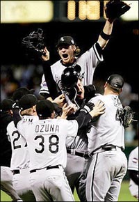 Joe Crede of the Chicago White Sox jumps onto his teammates in celebration after winning Game Four of the 2005 Major League Baseball World Series 1-0 against the Houston Astros at Minute Maid Park in Houston, Texas.