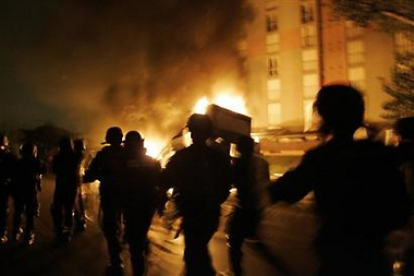 French riot police officers run past burning cars in Paris suburb, Aulnay-sous-Bois, early Thursday, Nov. 3, 2005. For a seventh straight night, groups of youths set fire to cars and shops in at least nine towns northeast of the capital. (AP Photo/Christophe Ena