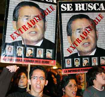 Peruvians protest against former Peruvian President Alberto Fujimori, holding posters with his picture, after his arrival in neighbouring country Chile, in front of the Chilean embassy in Lima, November 6, 2005.