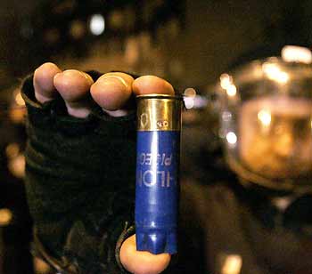 French police holds a shotgun shell recovered after they were shot upon in Grigny, south of Paris on the 11th night of violence late November 6, 2005.