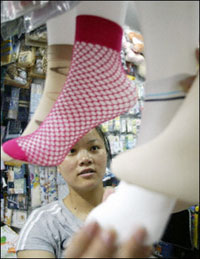 A shop assistant puts socks on mannequin feet in a store in Beijing. The US government said it had made 'substantial progress' in a fresh round of talks with China in a bid to forge a comprehensive agreement on textiles trade(AFP