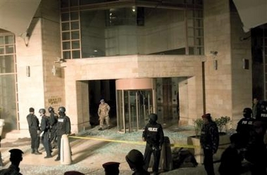 Police guard the entrance of a shattered front to the Hyatt hotel in Amman, Jordan, approximately one hour after a bomb exploded in the main lobby, Wednesday Nov 9 2005.
