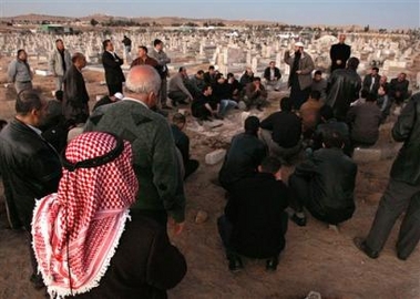 Relatives and friends gather and pray at the grave of Abdul-Khatib after they buried him at Sahab cemetery, in Sahab, southeast of Amman, Jordan, Thursday Nov. 10, 2005, after he was killed in one of the hotel explosions in the Jordanian capital, Amman.