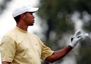 US golfer Tiger Woods receives a ball from his caddy during the second day of the Champions golf tournament in Shanghai, China November 11, 2005.