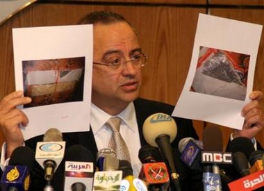 Jordanian Deputy Prime Minister Marwan al-Muasher holds pictures showing the explosive devices worn by a woman in Amman November 13, 2005.