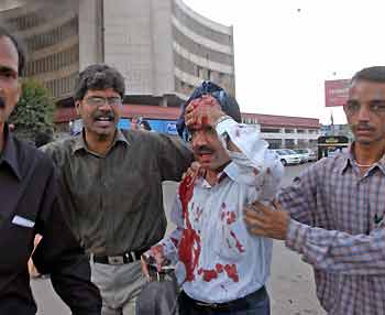 Pakistanis escort an injured man after a car bomb exploded in Karachi November 15, 2005.