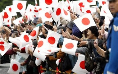 Well-wishers wave Japanese flags as Princess Sayako in a limousine passes by in motorcade leaving the outer garden of the Imperial Palace in route to a downtown hotel in Tokyo for her wedding with commoner Yoshiki Kuroda, Tuesday, Nov. 15, 2005. (AP