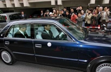 Yoshiki Kuroda (L, in car) leaves for his wedding ceremony with Japan's Princess Sayako in Tokyo November 15, 2005.