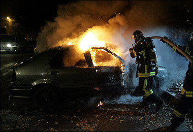 Firemen work on a burned car in the suburbs of Strasbourg, eastern France, 12 November 2005. 
