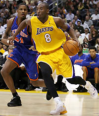 os Angeles Lakers Kobe Bryant (R) drives past New York Knicks Trevor Ariza during the third quarter of NBA action in Los Angeles November 16, 2005.