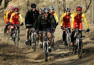 U.S. President George W. Bush rides his mountain bike with Chinese Olympic hopefuls on the Laoshan Olympic mountain bike course in Beijing, November 20, 2005.