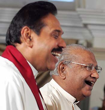 Sri Lanka's President Mahinda Rajapakse (L) and newly-appointed Prime Minister Ratnasiri Wickremanayake smile during the prime minister's swearing-in ceremony at the President House in Colombo, Sri Lanka November 21, 2005. Sri Lanka's new leader swore in a hawkish new prime minister on Monday in a move analysts said reinforced his hard-line stance on any future peace negotiations with the Tamil Tiger rebels.
