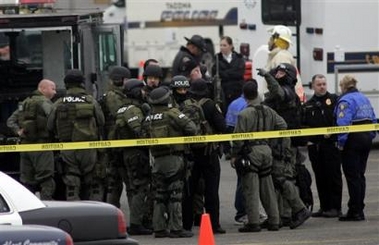 Police SWAT team members gathher in the parking lot of the Tacoma Mall, Sunday, Nov. 20, 2005 in Tacoma, Wash. A man was arrested Sunday afternoon, several hours after apparently walking inside the busy shopping mall where he took three hostages, Tacoma Police officials said. [AP]