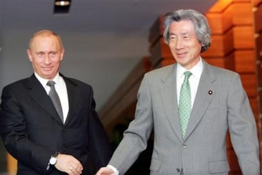 Russian President Vladimir Putin, left, is led by Japanese Prime Minister Junichiro Koizumi into a conference room for talks at his official residence in Tokyo Monday, Nov. 21, 2005. Putin and Koizumi began a summit meeting Monday expected to focus on economic issues, with the leaders unlikely to discuss a 60-year territorial dispute over four tiny, sparsely populated islands that has marred bilateral ties. [AP]