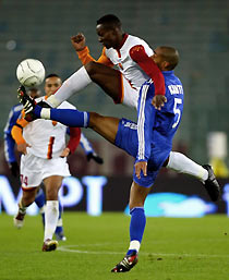 S Roma's Shabani Nonda (top) and Racing Strasbourg's C閐ric Kant?(R) fight for the ball during their UEFA Cup Group E soccer match at the Olympic Stadium in Rome November 24, 2005.
