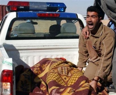 A man grieves near the dead body of his relative killed by a suicide bomber who drove his pickup into a crowded gasoline station in Samarra, Iraq, Saturday, Nov. 26, 2005. 
