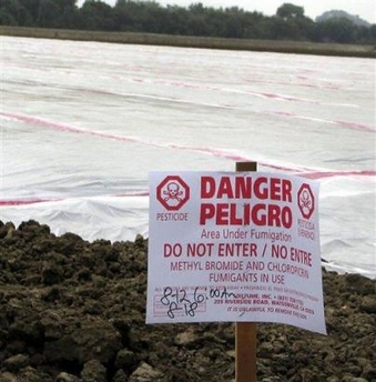 A sign, required by law, warns of a pesticide application of methyl bromide on a field near Watsonville, Calif., Aug. 12, 2005.