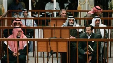 Awad Hamed al-Bandar (front L), Saddam Hussein (front R), Taha Yassin Ramadan (2nd row L), Abdullah Kazim Ruwayyid (2nd row C), Mizhar Abdullah Ruwayyid (2nd row R), Mohammed Azawi Ali (back row L), Ali Dayim Ali (back row C) and Barazan Ibrahim (back row R) sit during their trial in Baghdad's heavily fortified Green Zone November 28, 2005.