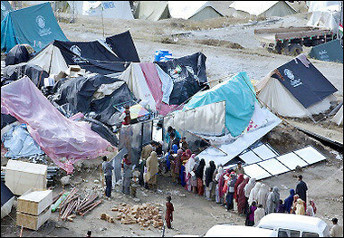 Pakistani earthquake survivors queue for relief supplies at a distribution camp in Muzaffarabad.