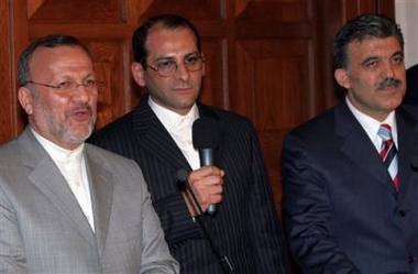 Iran's Foreign Minister Manouchehr Mottaki, left, speaks to the media after a meeting with his Turkish counterpart Abdullah Gul, right, in Ankara, Wednesday, Nov. 30, 2005. Mottaki said that talks with the European Union over Iran's nuclear program would resume within the next two weeks. Iranian translator is at the center( AP