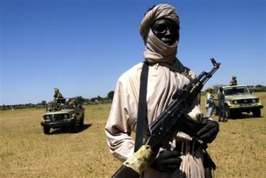 A heavily armed Sudanese rebel watches as Africa Union armoured vehicles deploy in Sudans Darfur region town of el-Fasher, November 18, 2005. [Reuters/file]