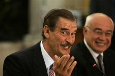 Mexican President Vicente Fox gestures as he speaks to foreign correspondents on the eve of his five year in office anniversary at the Los Pinos presidential residence in Mexico City, Mexico on Tuesday, Nov. 29, 2005. At right is Fox's spokesman Ruben Aguilar. [AP]