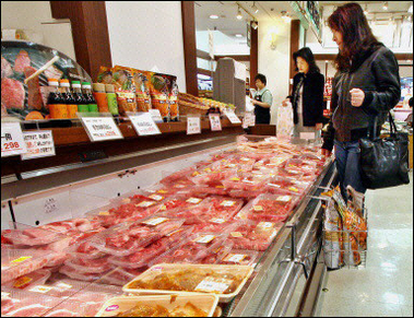 Customers check packets of beef in Tokyo.