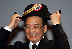 Premier Wen Jiabao puts on the traditional two-cornered hat of the Ecole Polytechnique in Palaiseau, France yesterday. The hat was presented to Wen by students at the prestigious French university. 			 REUTERS