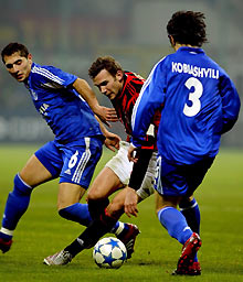 Andriy Shevchenko (C) is tackled by Schalke 04's Levan Kobiashvili (R) and Hamit Altintop during their Champions League Group E soccer match at the San Siro Stadium in Milan December 6, 2005.