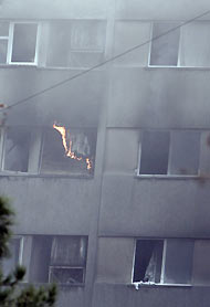 Smoke and flames rise from a building where a plane crashed in Tehran December 6, 2005. An Iranian military plane carrying at least 94 people crashed in flames into a Tehran apartment block on Tuesday, killing all those on board, police said. 